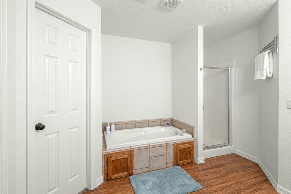 Primary bathroom with tub, walk-in shower, and closet storage