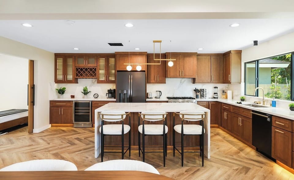 Kitchen is equipped with refrigerator, stovetop, dishwasher, oven with a view of the yard. 