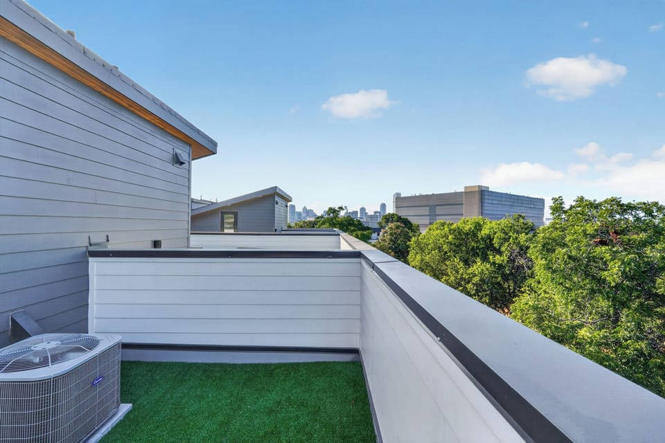 Private rooftop terrace with turf and treetop views toward the city skyline