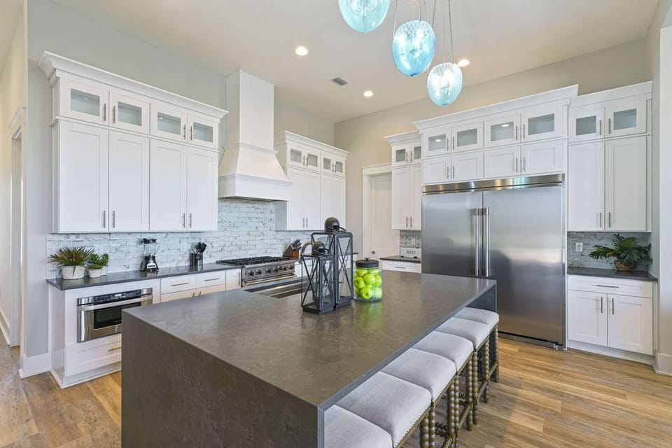 Commercial Kitchen Hub: Professional culinary setup featuring a commercial gas range, double ovens, and stainless steel fridge, island seating, and a walk-in pantry. Ideal for catering multi-family vacations, holiday meals, and morning breakfast bars.