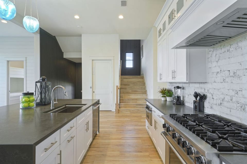 Cook for large groups on the 2nd floor! The chef-grade gourmet kitchen features a commercial 60" gas range, dual ovens, double dishwashers, oversized refrigerator/freezer, and massive island designed for effortless culinary operations.