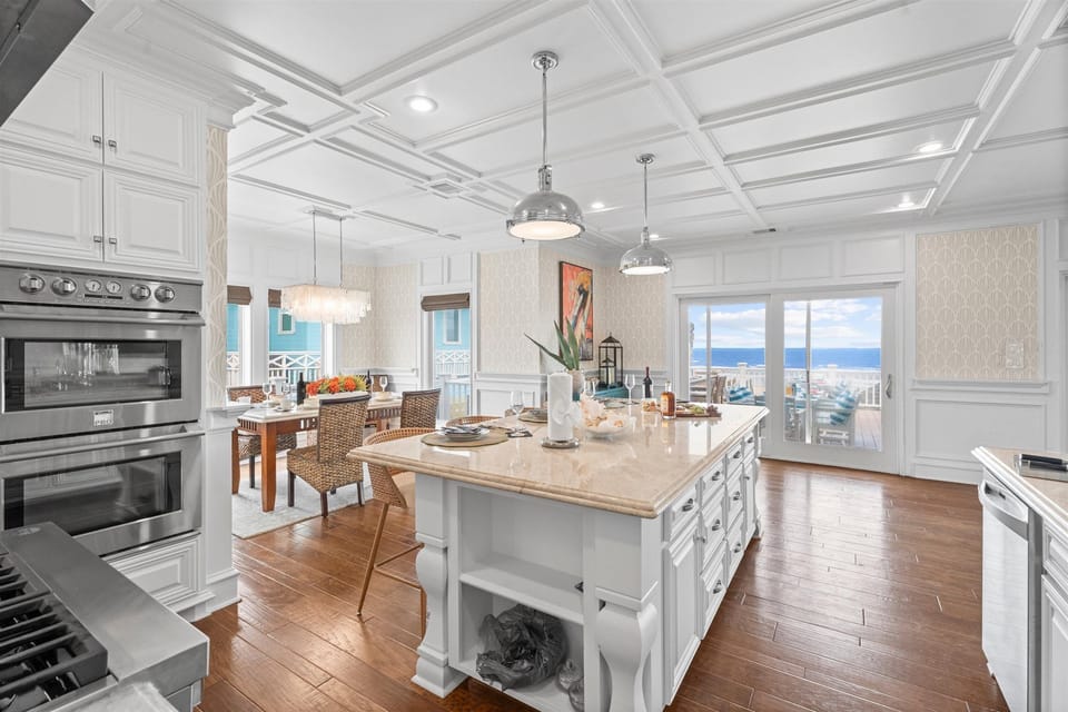 Spacious kitchen featuring a large center island, abundant counter space, modern appliances, and beautiful ocean views from the dining area.