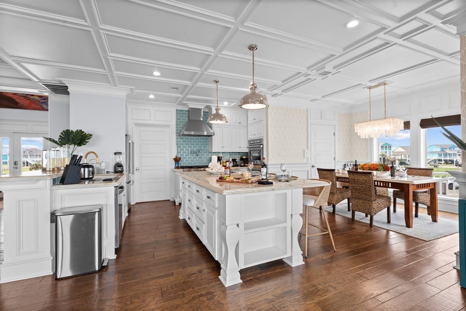 Bright open kitchen featuring a large island, modern appliances, generous preparation space, and an adjoining dining area for group meals.