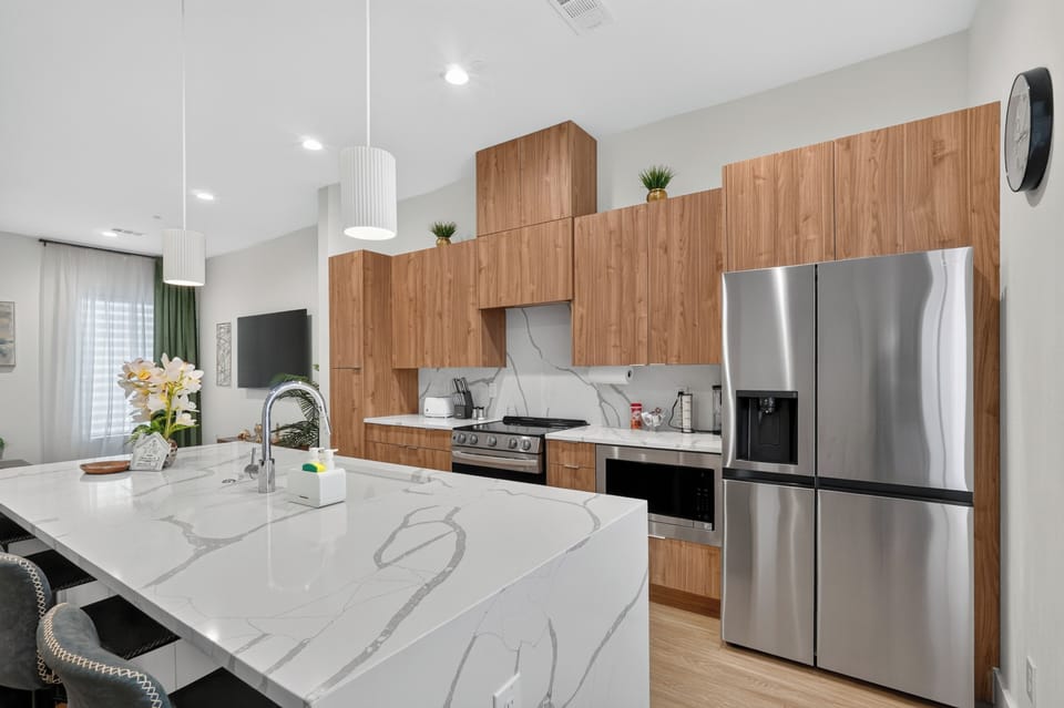 Bright modern kitchen with waterfall island and sleek stainless appliances