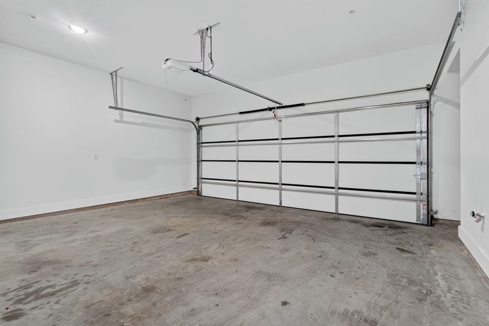 Spacious clean garage with automatic opener and extra storage potential