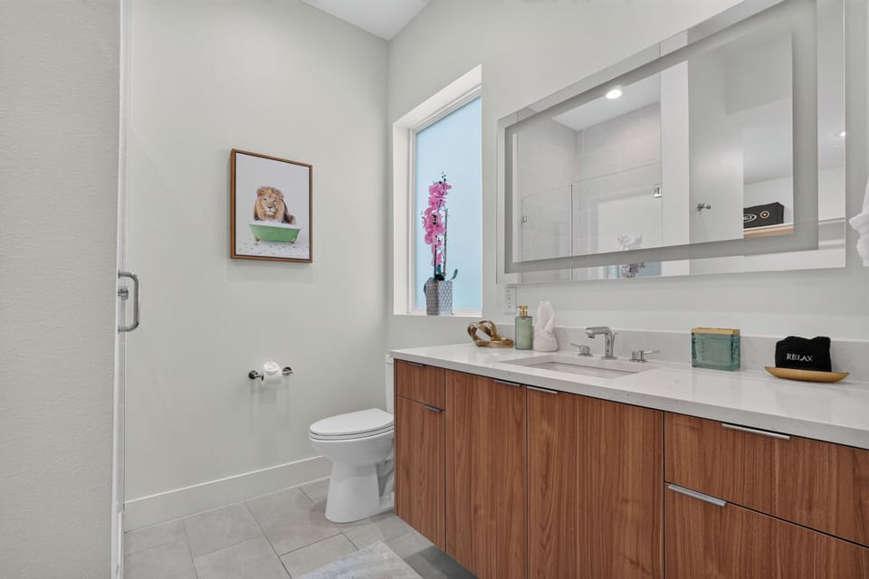 Bright modern bathroom with sleek vanity, glass shower, and spa-like style