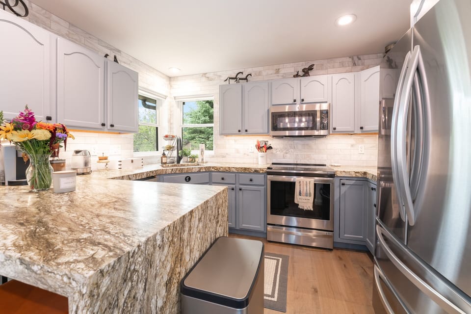A chef's kitchen with granite counters and space to spread out I Upper Level