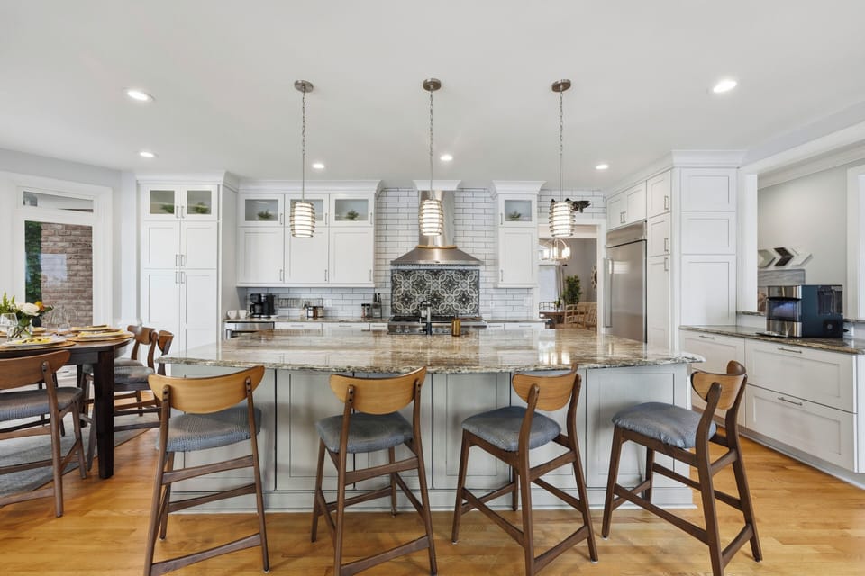 A generous kitchen island offers seating for four, with plenty of prep space and a bright, open setup for cooking and casual meals.