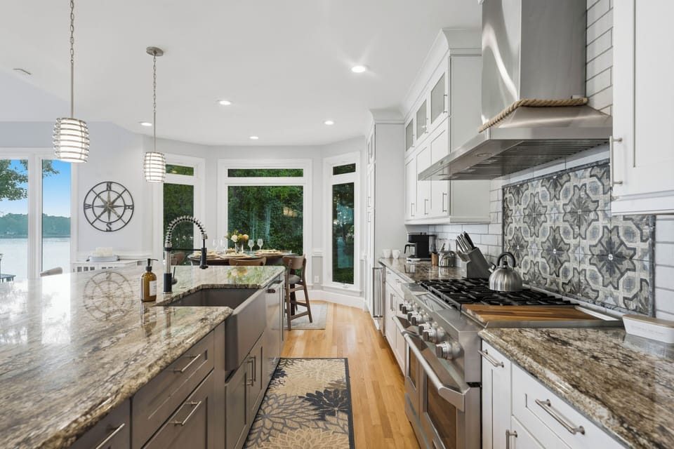 A well-equipped kitchen combines generous counter space, a farmhouse sink, and a professional-style range, with lake views just beyond the windows.