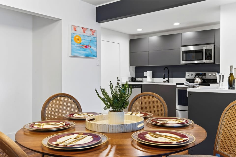 Set dining table beside a streamlined kitchen island with ample counter space.