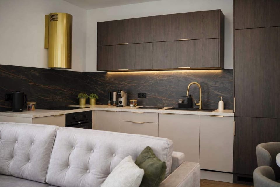 A modern dark kitchenette with cabinets, countertop, and cooking area.