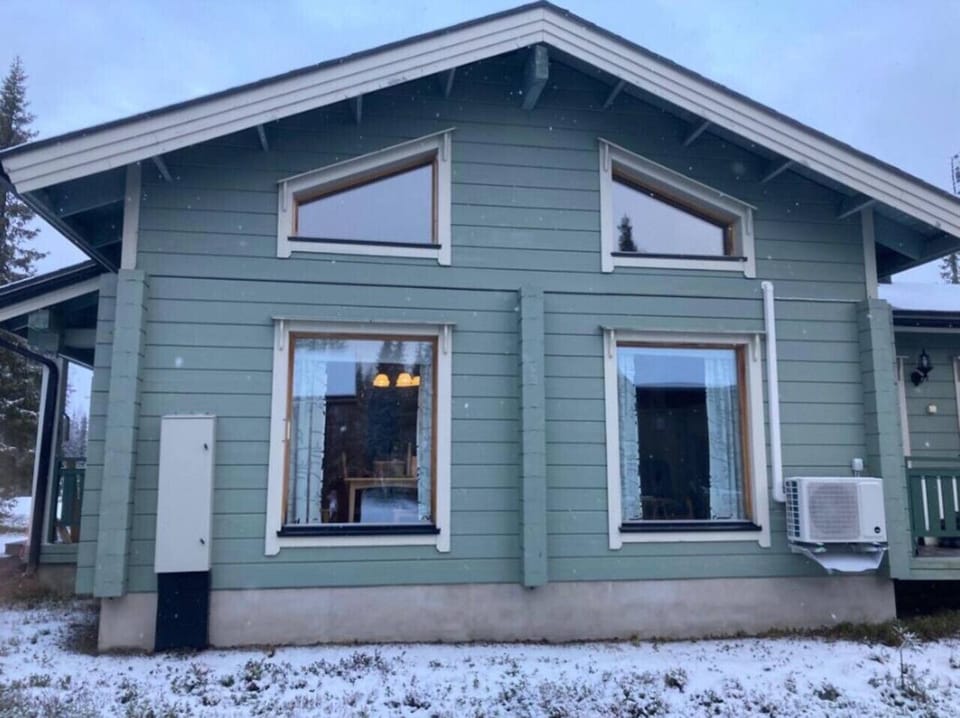 Exterior view of the log building with large windows and a terrace.