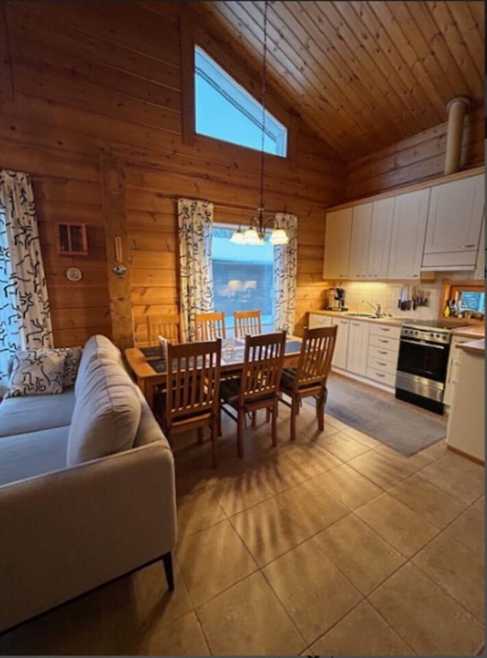 Wooden dining table with seating next to the open-plan kitchen.
