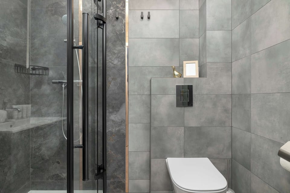 The bathroom's contemporary design includes fresh towels and a hairdryer.