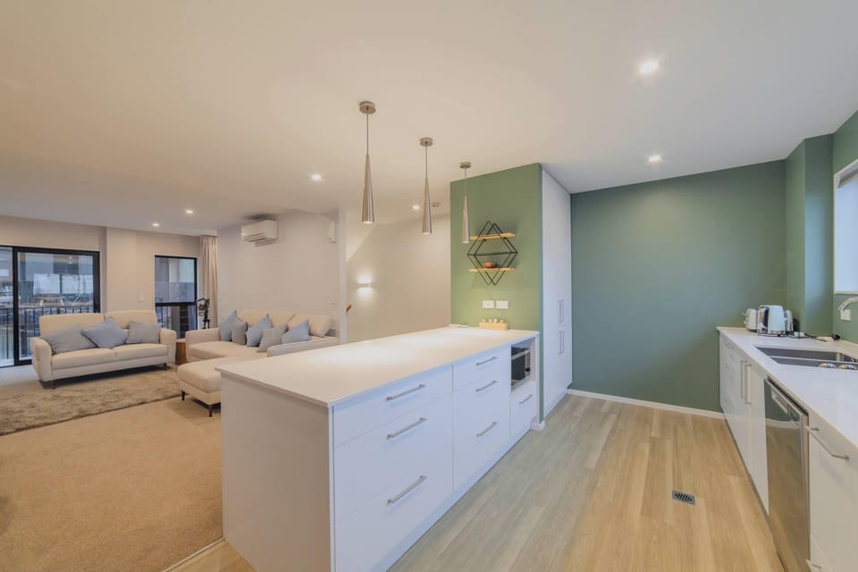 Spacious kitchen island with drawers and preparation space, opening directly to the lounge and dining area in central Christchurch.