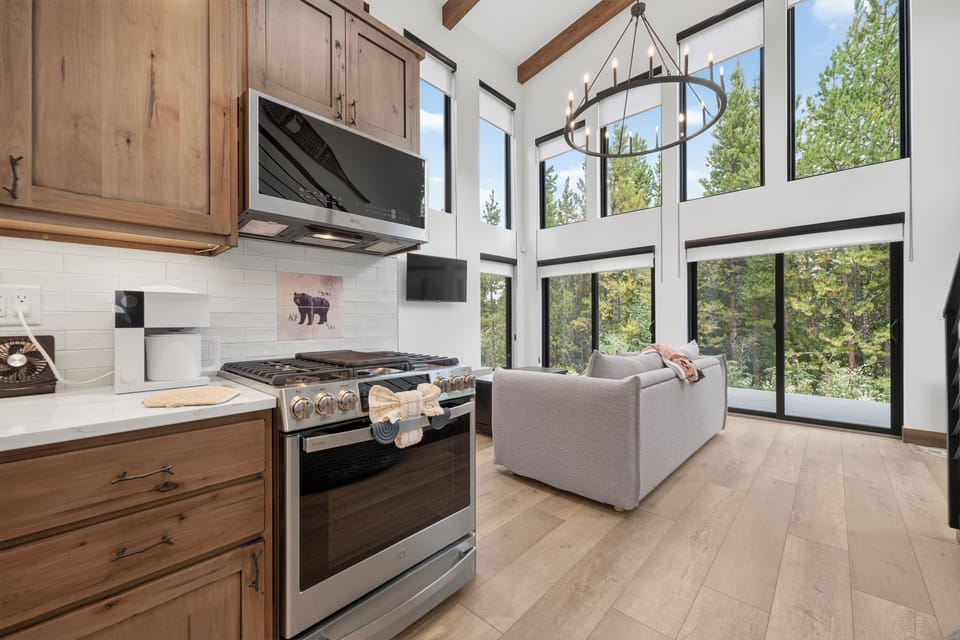 Soaring windows frame your treetop retreat, where sunlight pours over the open-plan kitchen and living space. Cook, relax, and soak in nature's beauty—all from one stunning room.