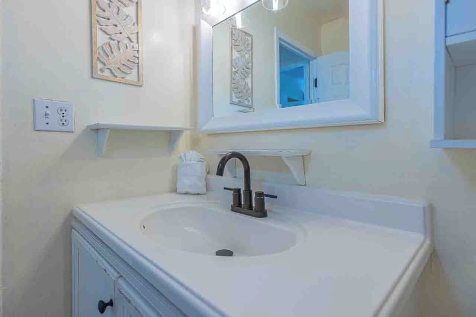 Freshen up in your bright, coastal-inspired bathroom with crisp white vanity and charming seaside accents that set a relaxing tone.