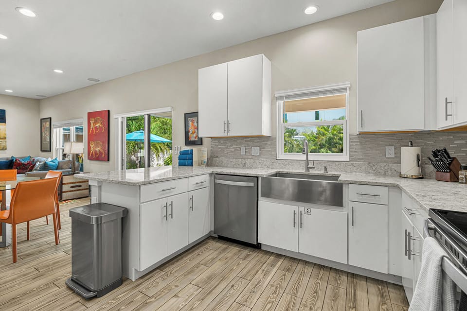 Sunshine streams through the windows of your bright, modern kitchen, where sleek white cabinetry and gleaming granite counters invite you to whip up a delicious meal. Open to the living area, it's perfect for gathering with loved ones.