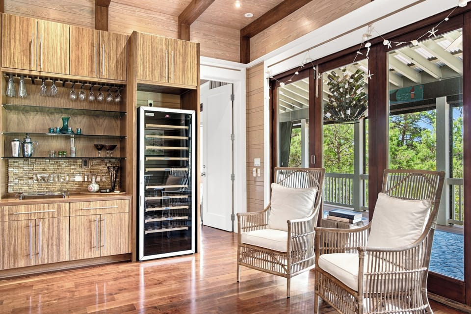 Step into your sleek kitchenette with warm wood tones and modern touches, where open doors reveal a serene treetop view stretching just beyond your private retreat.