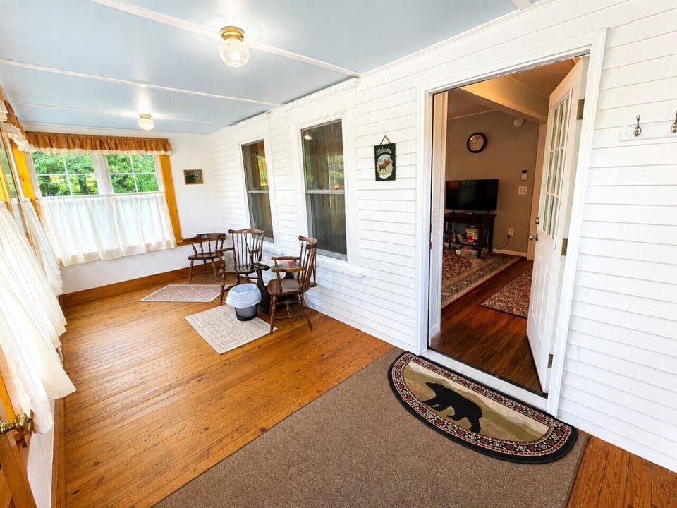 Bright enclosed porch with plenty of natural light and space to sit and relax.
