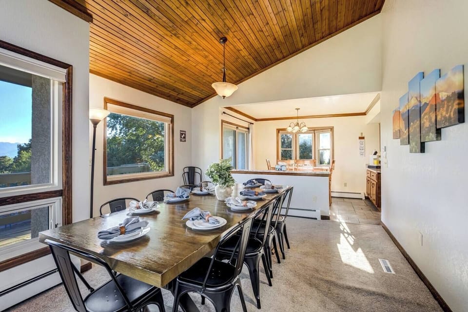 The dining table set for ten, with the kitchen bar just beyond

