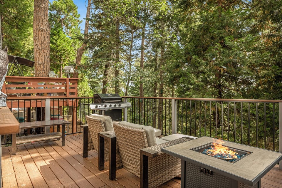 Private forest-view deck with fire table, lounge seating, and grill