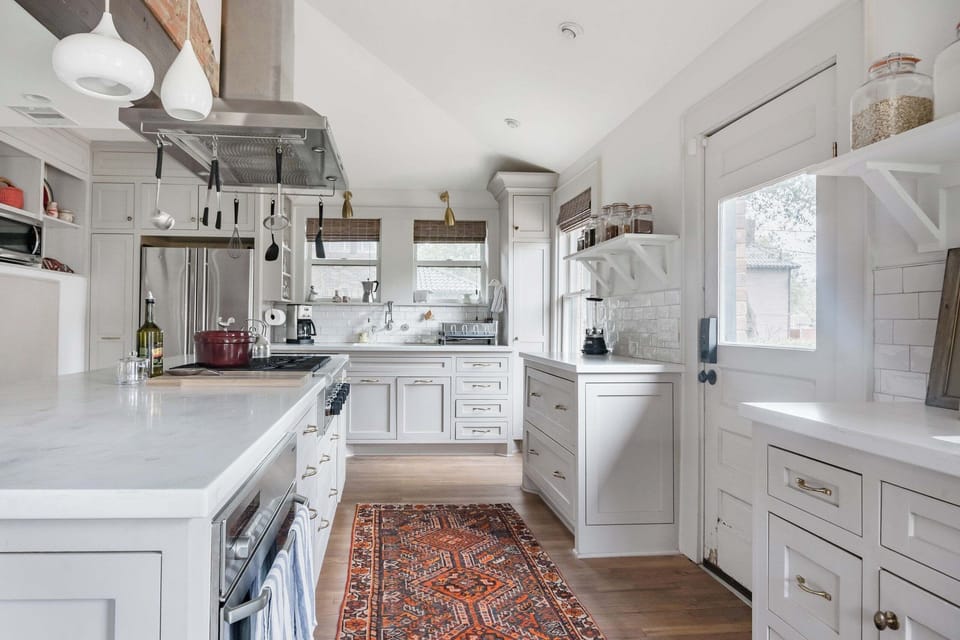 Bright designer kitchen with island, open shelving, and stylish finishes