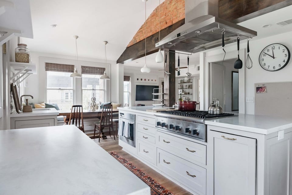 Bright chef’s kitchen with oversized island, gas range, and sunny dining nook