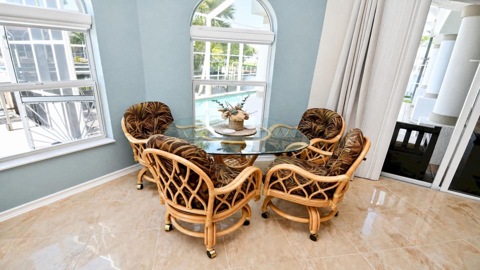 Cozy breakfast nook for four with large windows overlooking the pool and waterfront.