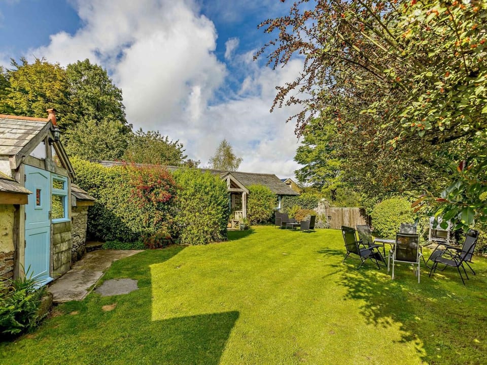 View through large, enlcosed garden with piggery on left and main cottage ahead