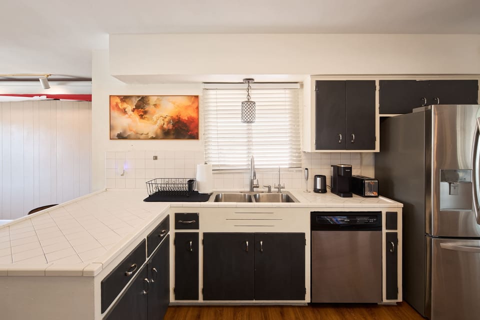 Cooks can spread out at the tile counters in the kitchen, stainless steel appliances and a pass-through bar keeping the space connected to the dining and living areas beyond.