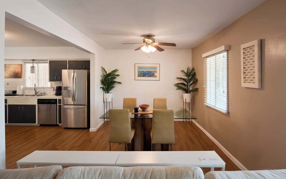 Four can gather around the glass top table in the dining area for a long, unhurried dinner, the warm accent wall and soft fan light carrying the evening past dessert.