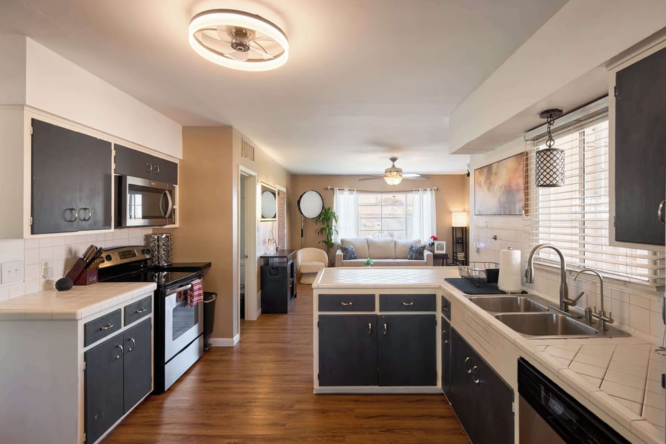 Cooks can spread out at the tile counters in the kitchen, stainless steel appliances and a pass-through bar keeping the space connected to the dining and living areas beyond.
