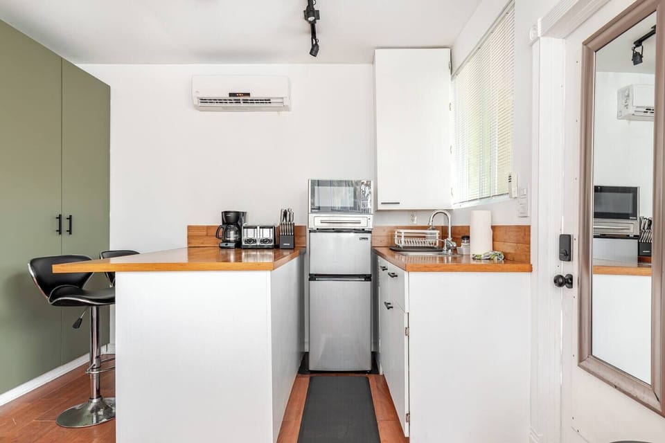 Well-equipped kitchenette with a full-size sink, microwave, mini refrigerator, coffee station, toaster, and generous counter space.