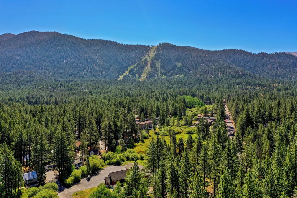 Scenic drone shot facing Heavenly Mountain Resort, highlighting the short drive to ski runs, hiking trails, and mountain adventures.