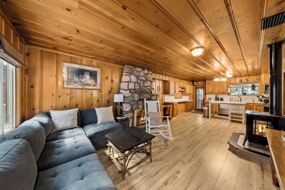Comfortable L-shaped sectional sofa centered around a floor-to-ceiling stone fireplace, perfect for gathering with family and friends.