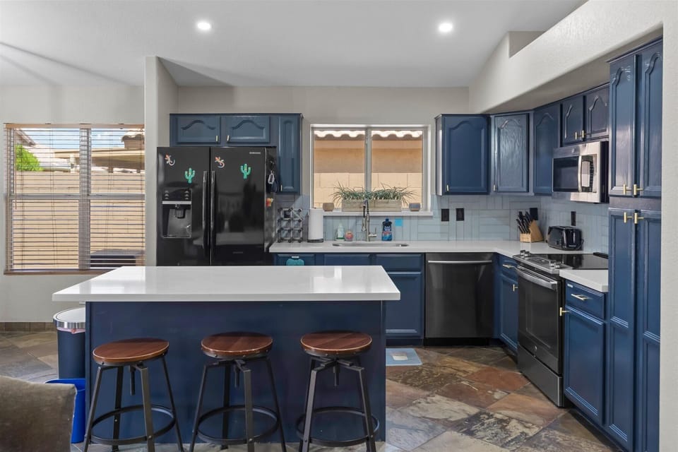 Fully stocked kitchen with a large island, bar seating, full-size appliances, and plenty of room for group meals.