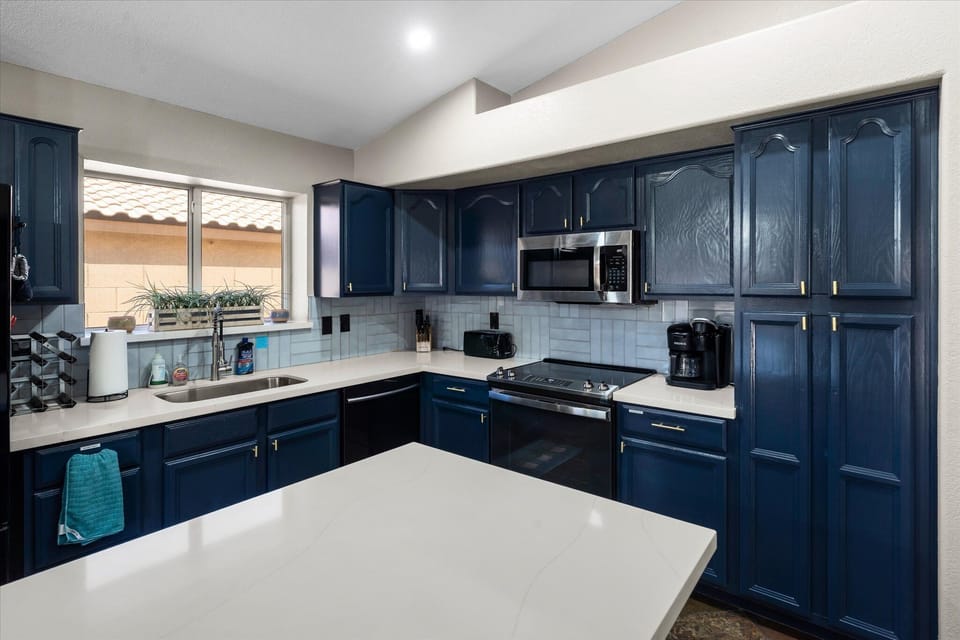 Well-equipped kitchen with generous cabinetry, full-size range, microwave, and counter space for meal prep.