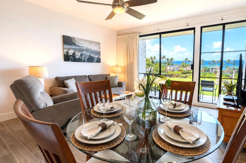 Primary bedroom at Napili Point B31 — king bed, private lanai access, and lush tropical views through the sliding glass door