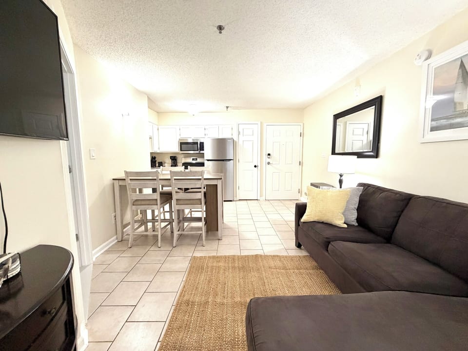 Bright open living space with bar seating, full kitchen, and cozy sofa
