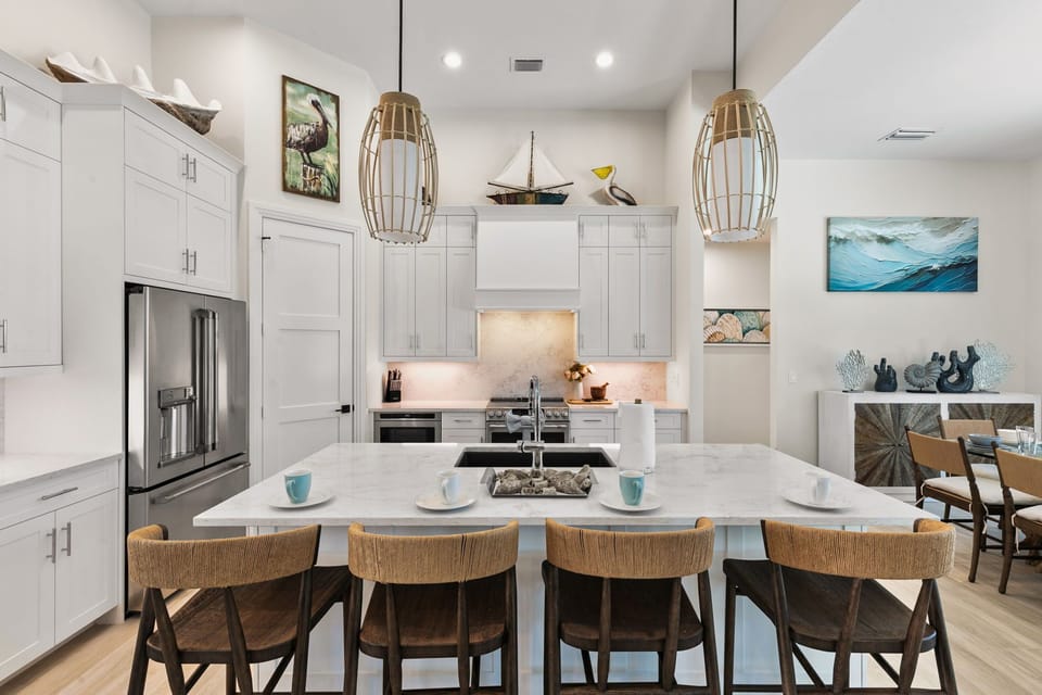 Gather around the spacious kitchen island where meals become memories. Soft pendant lighting and coastal-inspired décor create an inviting space for cooking, dining, and conversation with your travel companions.