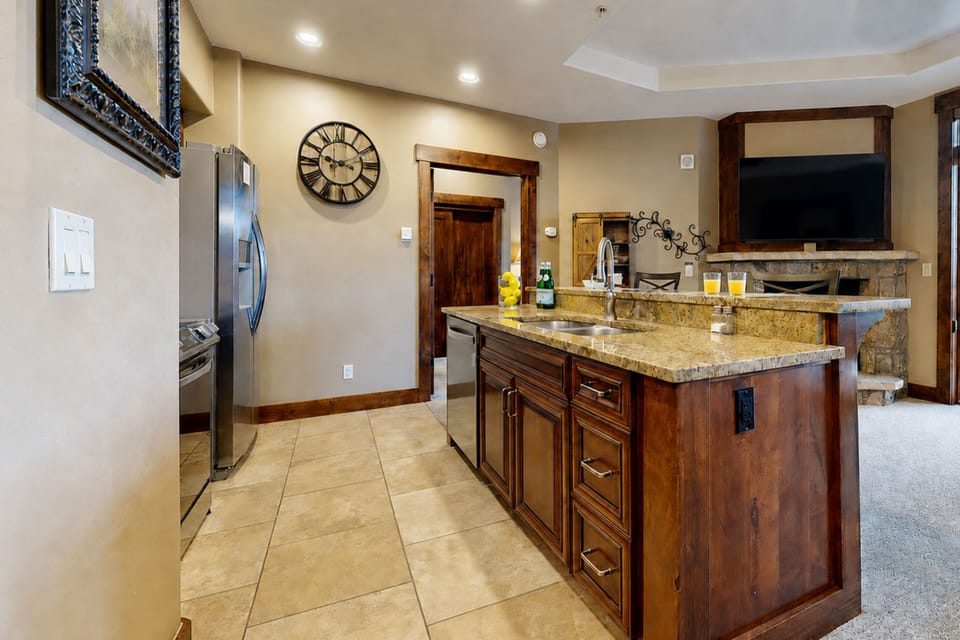 Your fully equipped kitchen features rich wood cabinetry, granite countertops, and modern stainless steel appliances—perfect for preparing your favorite meals during your stay.