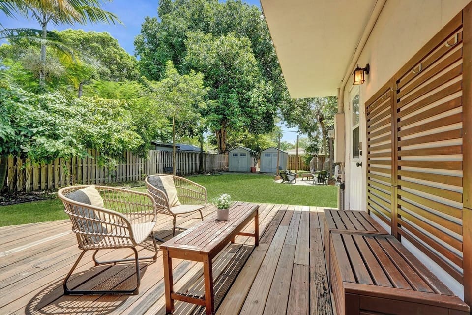Wooden deck with lounge chairs overlooking the big green yard.