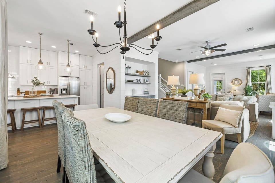 Gather around the farmhouse-style dining table where coastal-chic meets modern comfort. Your open-concept space flows seamlessly from kitchen to living areas, bathed in natural light and designed for memorable moments together.