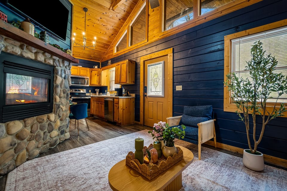 Unwind by the glowing fireplace after a day out, with a cozy lounge area and kitchen perfect for a quiet night in.
