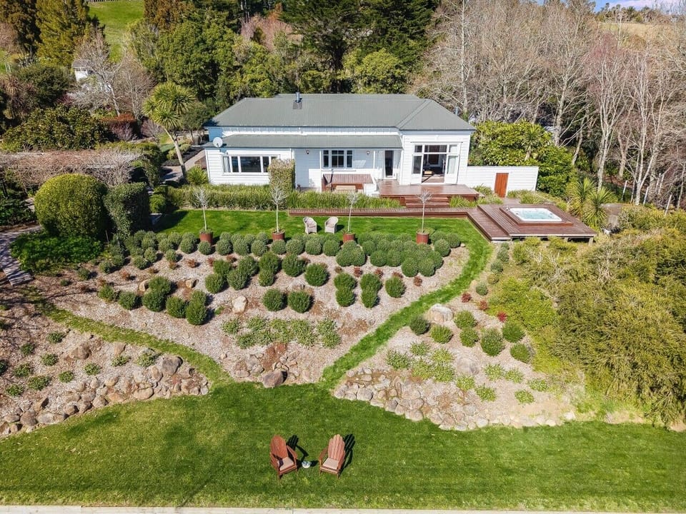A peaceful countryside setting with expansive gardens and rolling farmland beyond