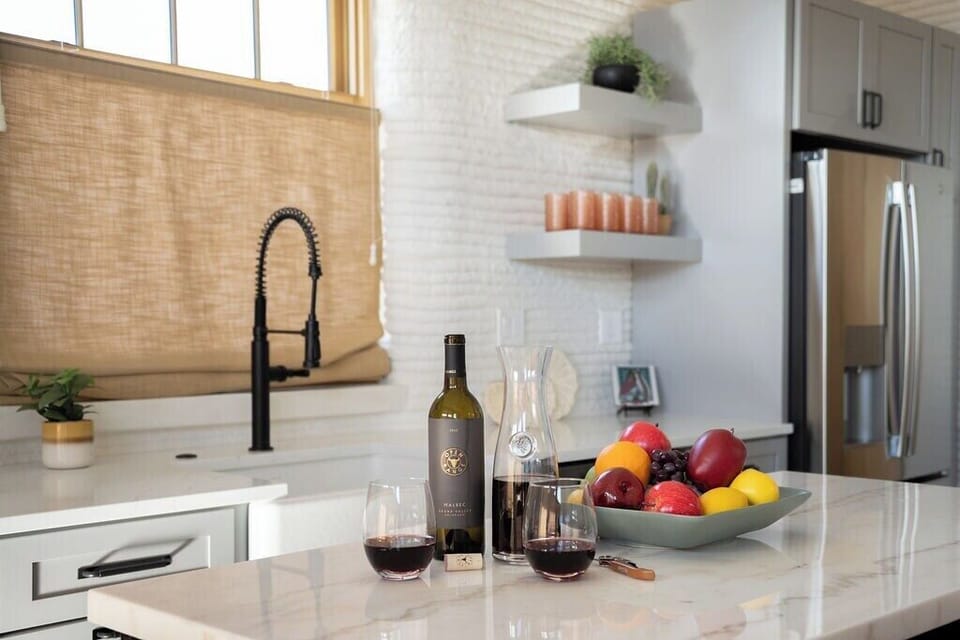 Spacious kitchen island with bar stools for additional dining seating or fully functional workspace.