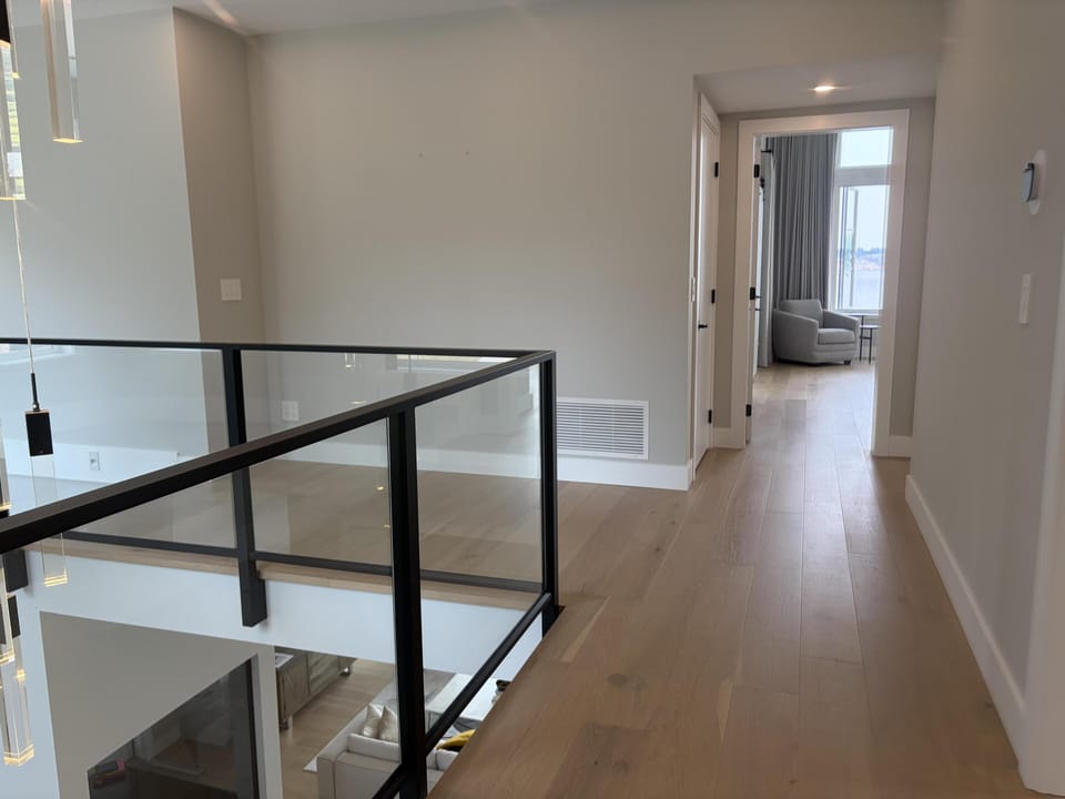 Upper-level hallway balcony overlooking the expansive open-concept main floor below.