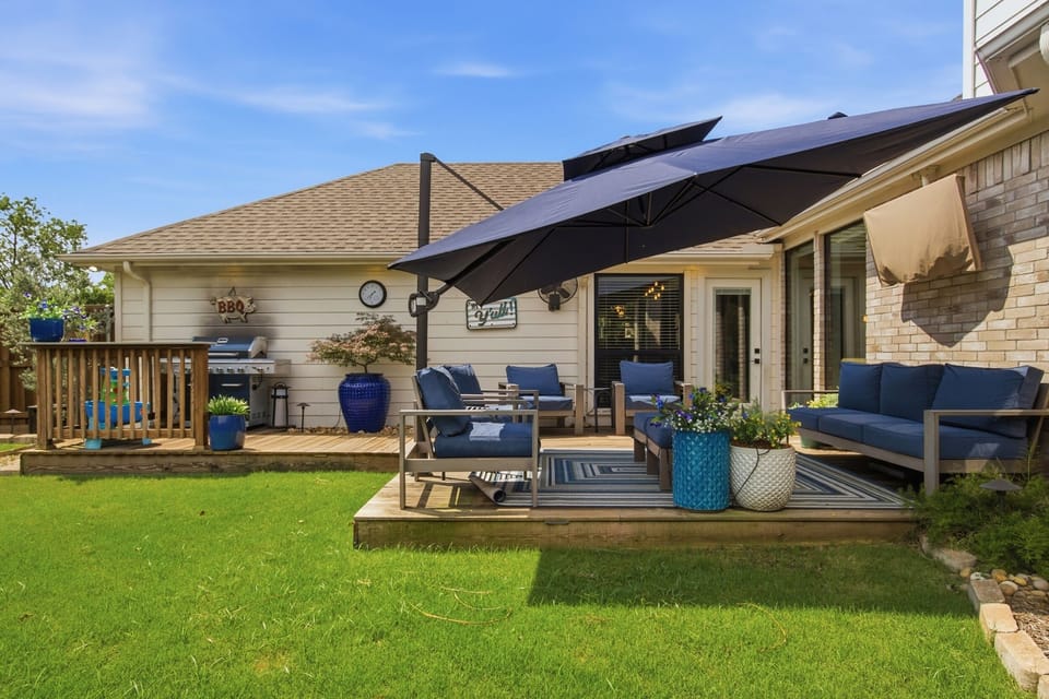 Wide-angle view of the wooden Deck and Backyard with multiple seating zones, lush lawn, and total privacy backing up to no rear neighbors.
