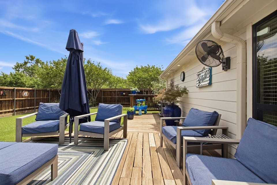 Patio dining and lounging area on the raised Deck, with a shade umbrella and comfortable Outdoor Furniture, ready for the whole group to gather outside.
